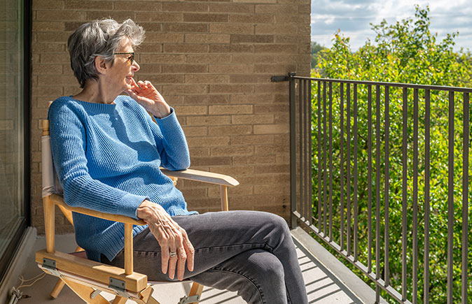 Senior homeowner relaxing on a sunny balcony
